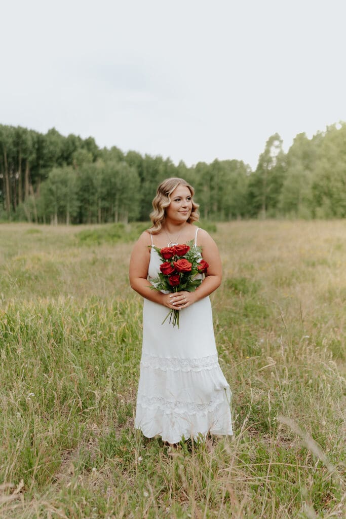 Senior portrait walking in a field showcasing soft natural lighting and a relaxed outdoor vibe.