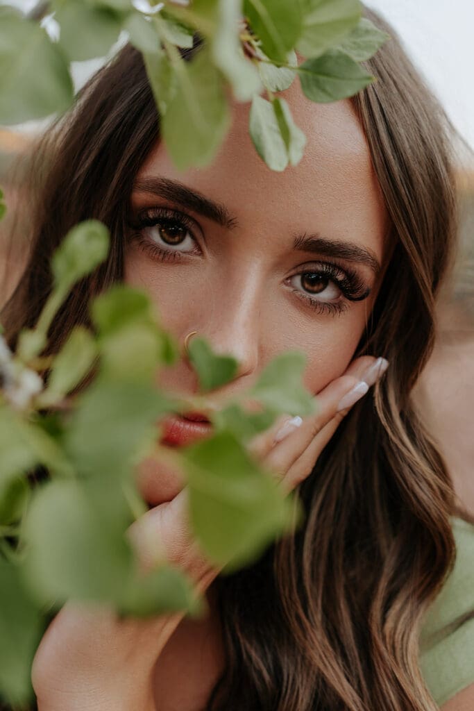 High school senior posing in front of red rock cliffs near Moab, Utah during golden hour
